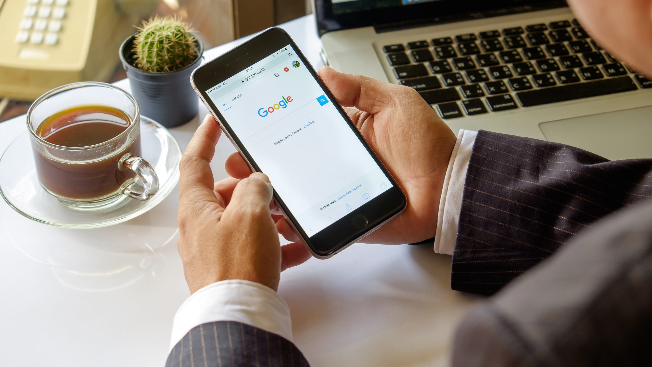 Person holding a smartphone displaying Google search, representing Google Ads and online advertising