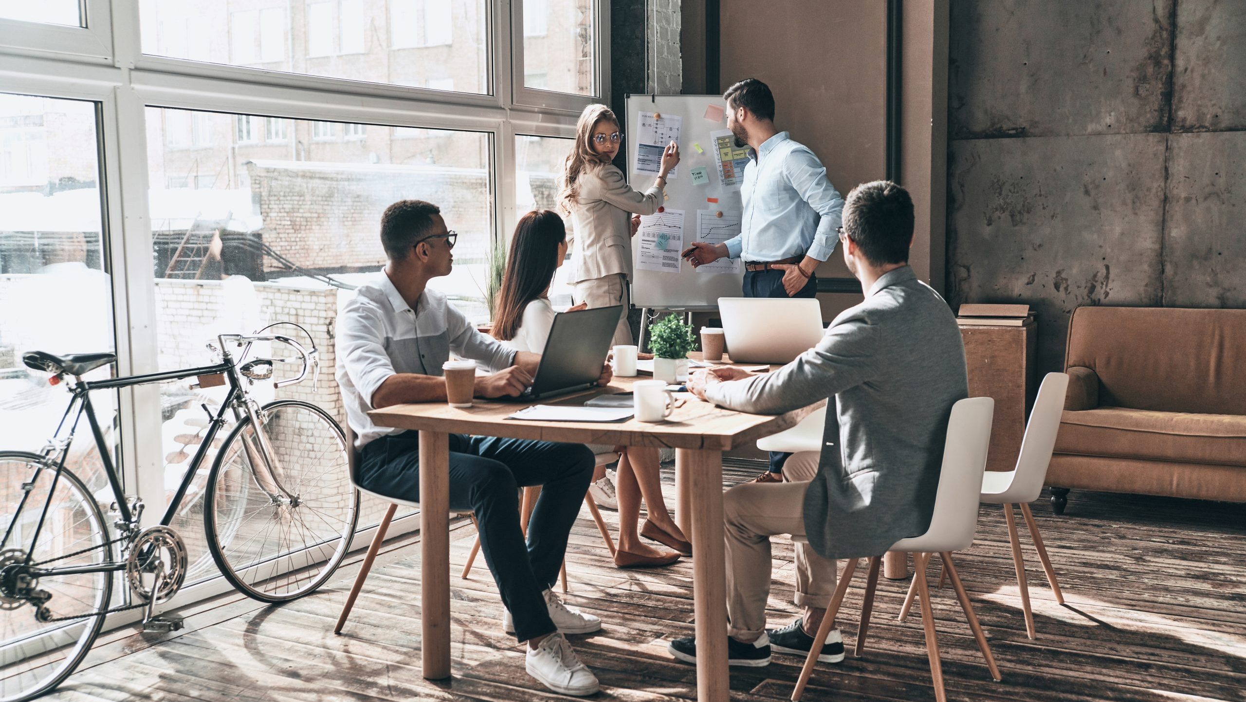 Team of designers and marketers collaborating in a modern Melbourne office during a creative strategy meeting.